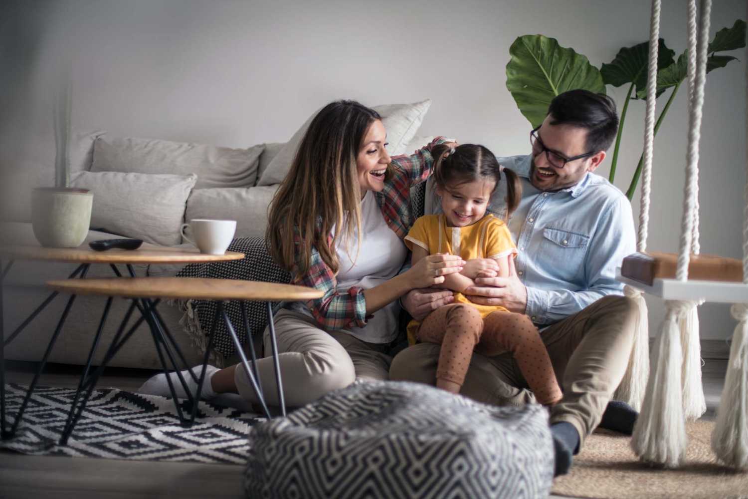 Happy residents spending their time with their child in a spacious living room at Fawn Haven Apartments in Butler, Indiana