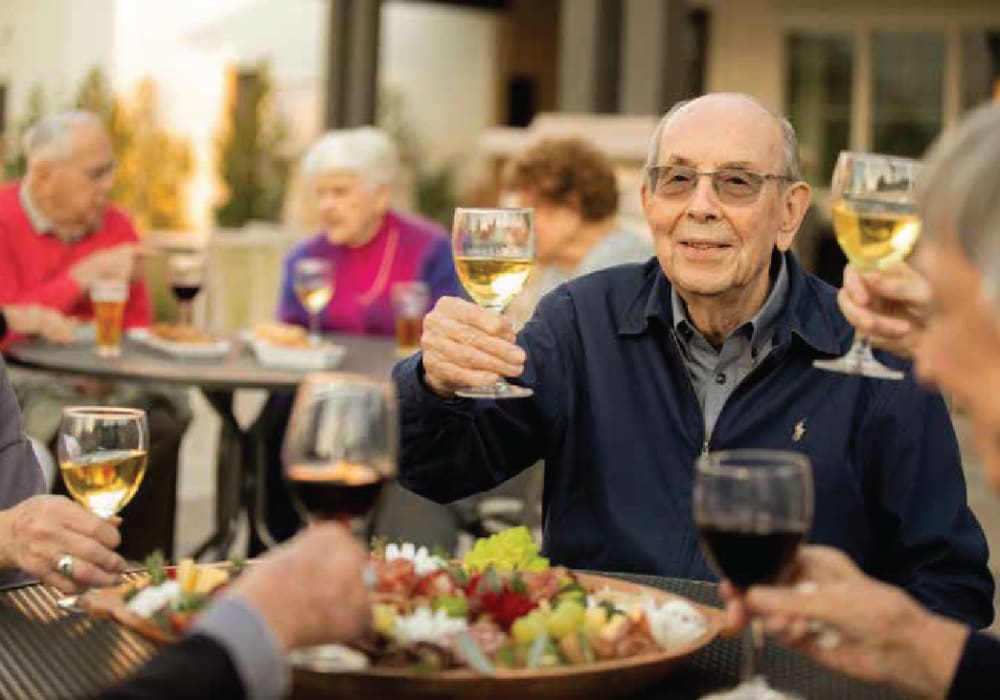 Residents toasting with wine at a meal at Clearwater at The Arboretum in Austin, Texas