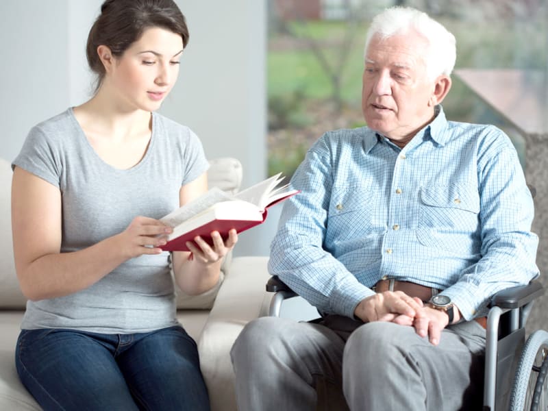 A caregiver reading to a resident at Transitions At Home in Elkhorn, Wisconsin