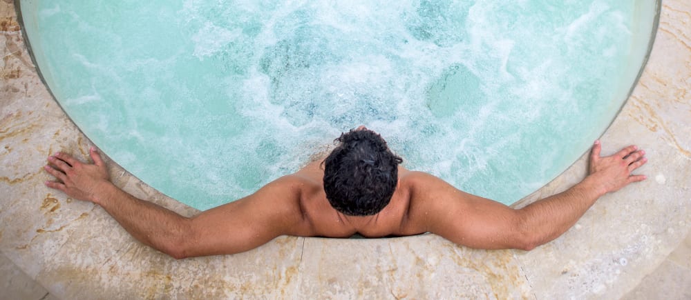 A man relaxing in the resort-style hot tub at Harborside Marina Bay Apartments in Marina del Rey, California