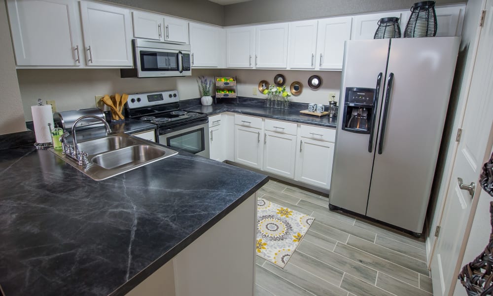 Bright kitchen with black granite counters at Cottages at Tallgrass Point Apartments in Owasso, Oklahoma