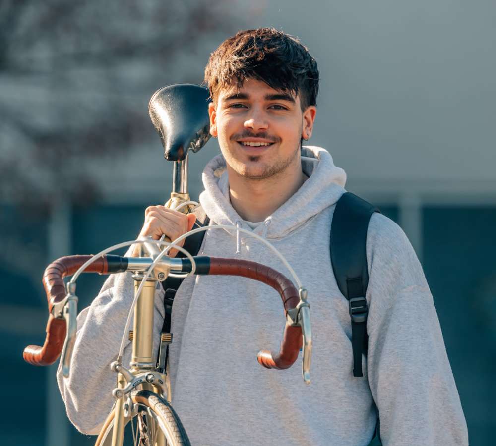 Student carrying a bike near The Edge in Pensacola, Florida