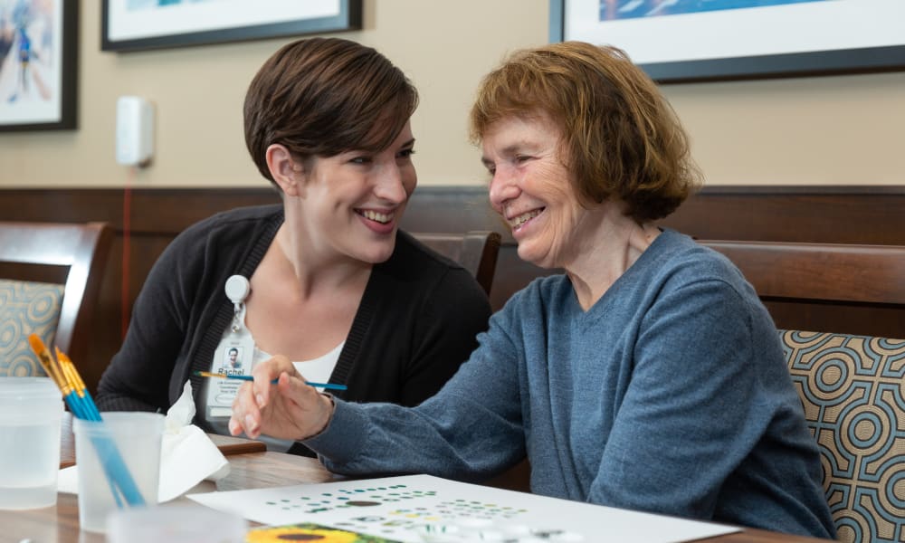 A resident and caretaker doing an activity together at Touchmark at Meadow Lake Village in Meridian, Idaho