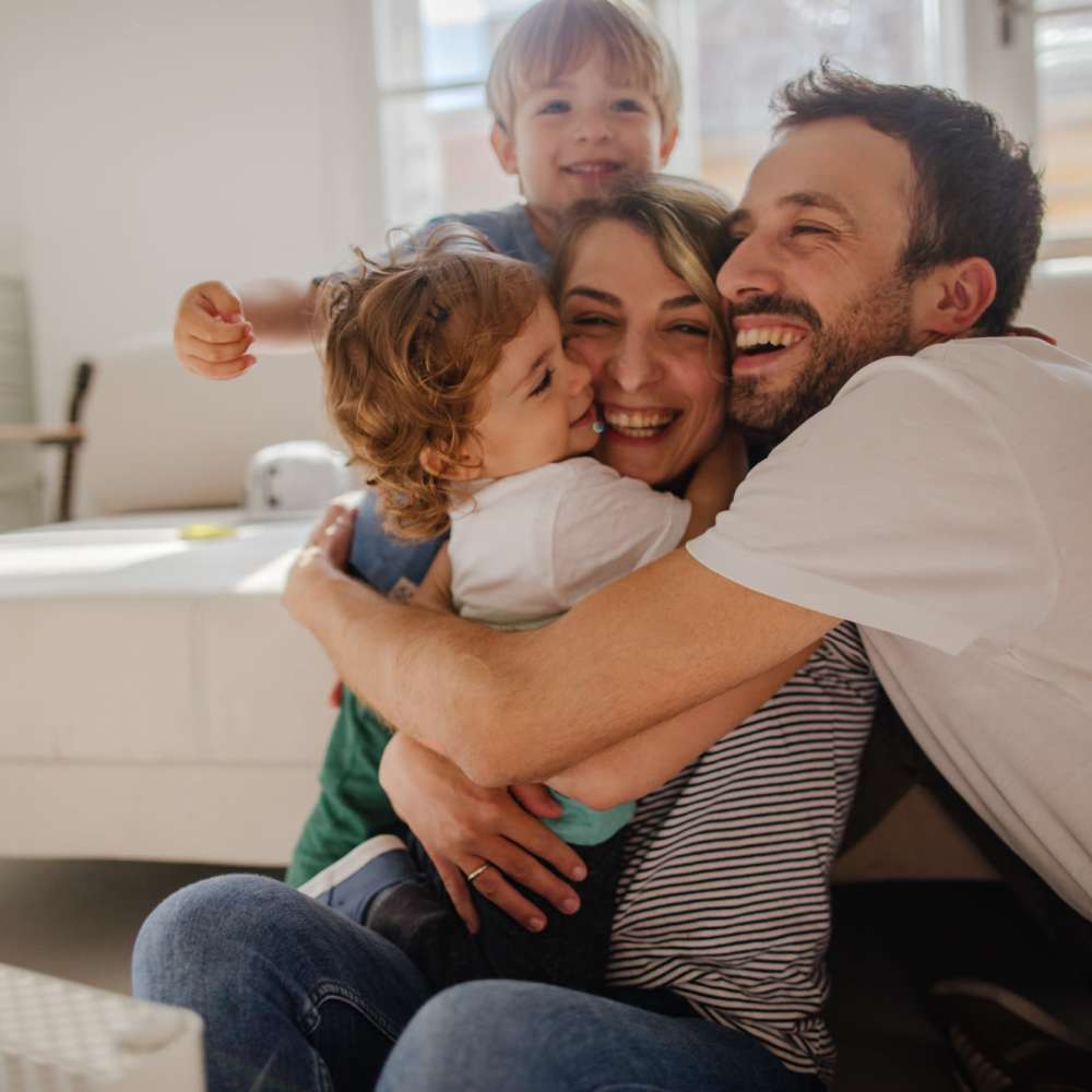 Resident family sharing a laugh in their apartment at El Paisano in Laredo, Texas