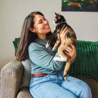 Resident with her pet in living room at Dorian and Encore in Plano, Texas