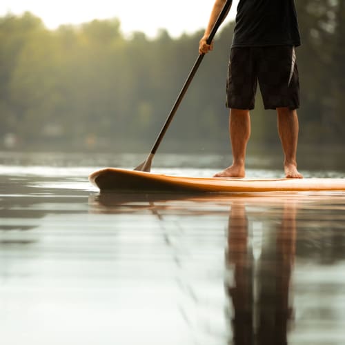 Resident on a paddleboard nearby at Meridian at Stanford Ranch in Rocklin, California
