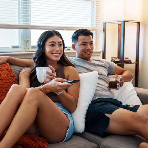 Couple enjoying together in a living room at Heritage Park Apartments & Townhomes in Webster, New York