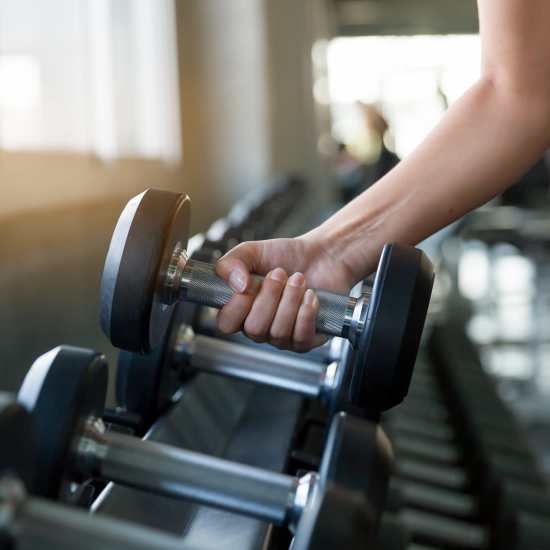 Resident picking up a dumbbell at The Meadowlark at Fairview in Fairview, Oregon