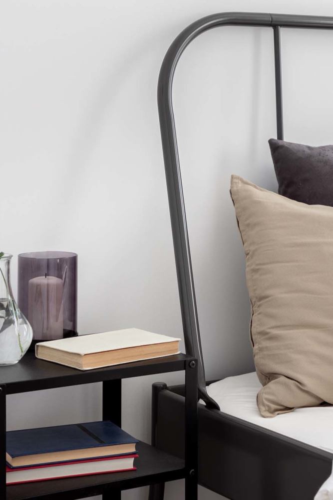 Bed and nightstand at Monamos Terrace Apartments in Murrieta, California