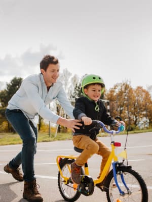 Resident father teaching son how to bike at Apple Creek Apartments in Stillwater, Oklahoma