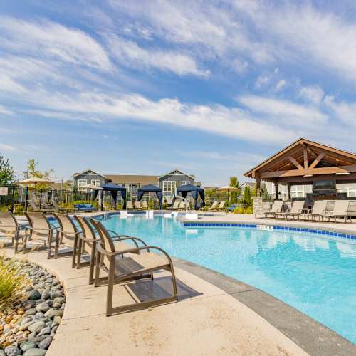Pool area with lounge seating at Villas On Fir in Granger, Indiana