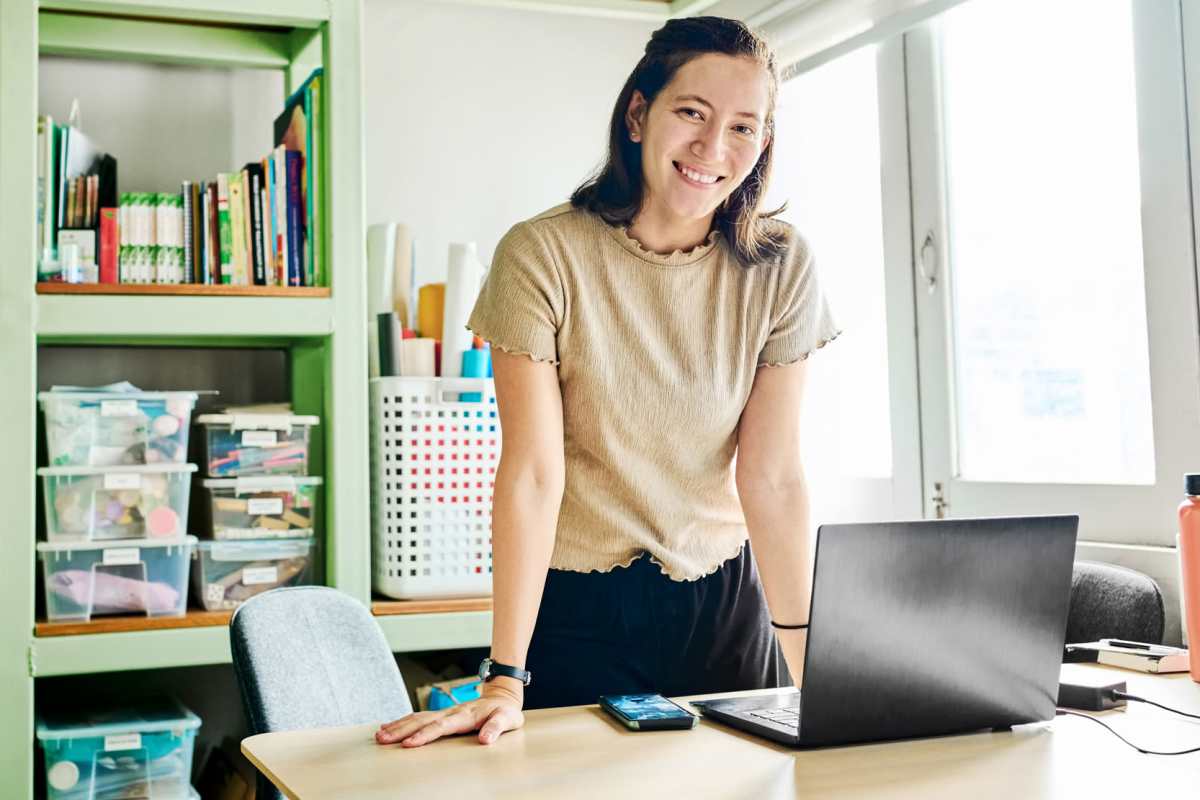 Woman smiling at desk with laptop at Oak Creek in New Braunfels, Texas