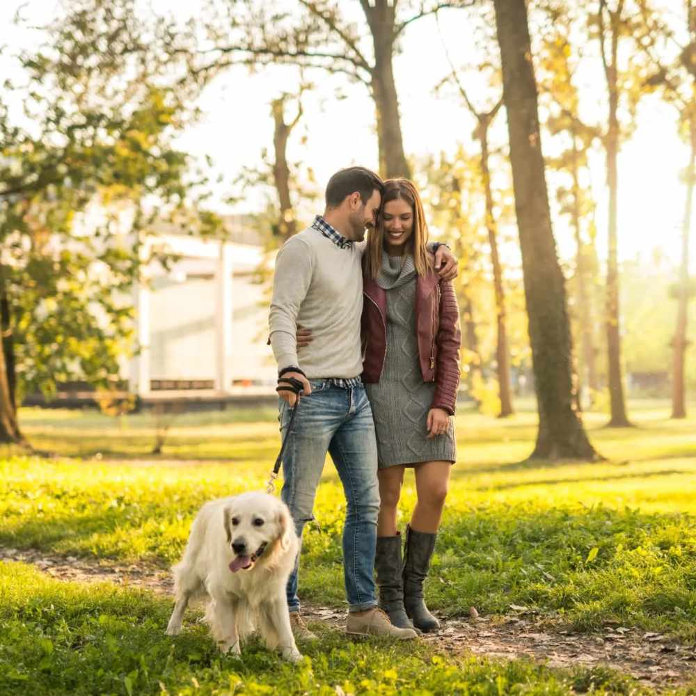 Happy couple walking with their dog in a park near À L'aise Hyde Park in Cincinnati, Ohio