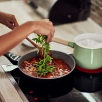 A woman cooking in her kitchen at Retreat at Fairhope Village in Fairhope, Alabama