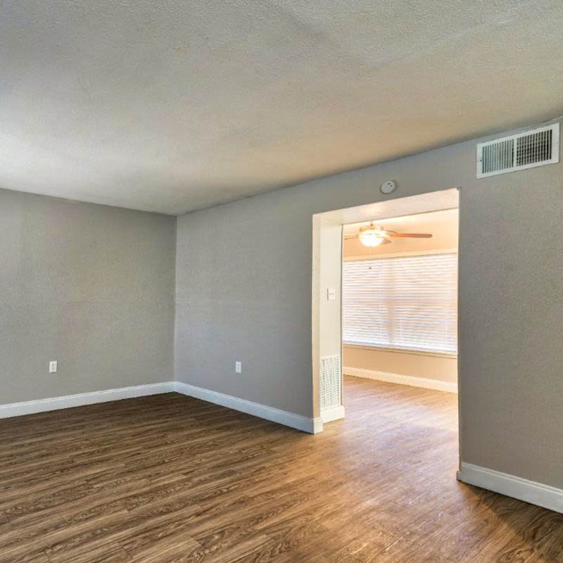 Spacious living room with windows and ceiling fan at Troup Townhomes in Troup, Texas