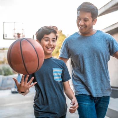 A father and son playing basketball at Miramar Townhomes in San Diego, California