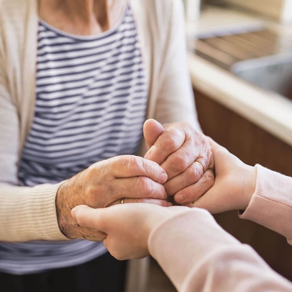 Caretaker and senior holding hands at Anthology of Wildwood in Wildwood, Missouri