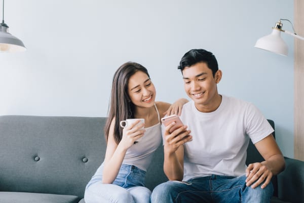 Couple sitting on the couch after getting all moved into their new place at Reserve at Centerra Apartment Townhomes in Loveland, Colorado