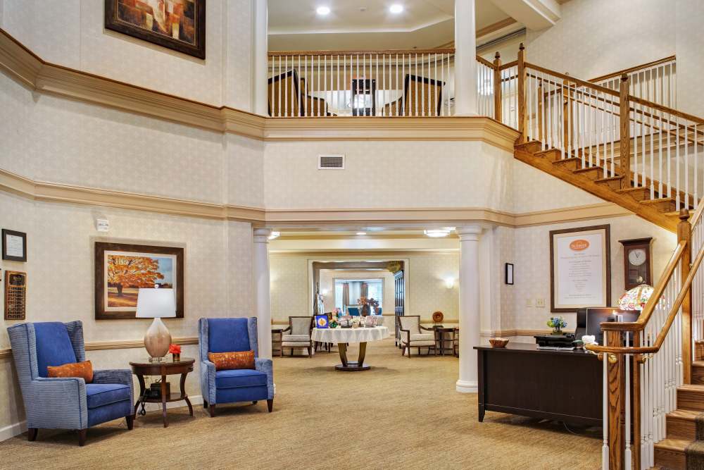 Grand lobby with staircase and seating areas at Glenncrest at Johns Creek in Johns Creek, Georgia