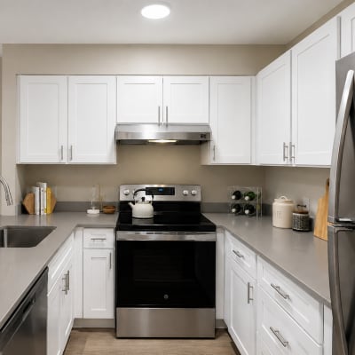 Modern kitchen with stainless steel appliances, quartz countertops, and white shaker cabinetry in a model home at Sofi at Somerset in Bellevue, Washington  