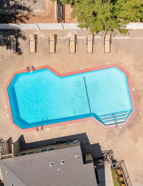 Large community swimming pool with multiple sun loungers to relax at Woodlake Close in Sacramento, California