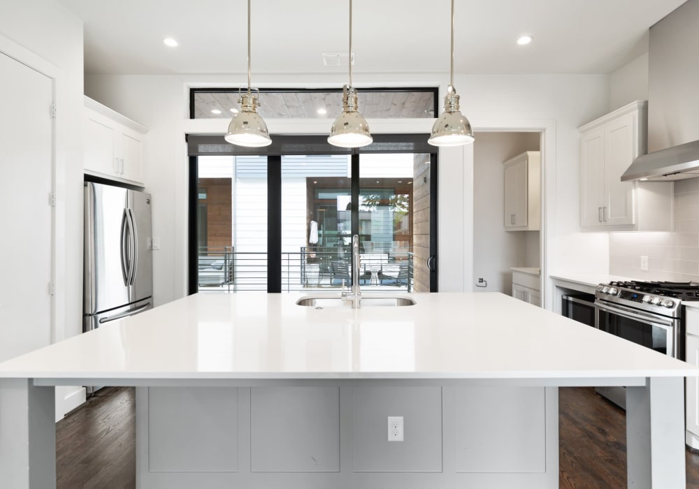 Modern apartment kitchen with white marble countertops and stainless steel appliances at The Collection Townhomes in Dallas, Texas