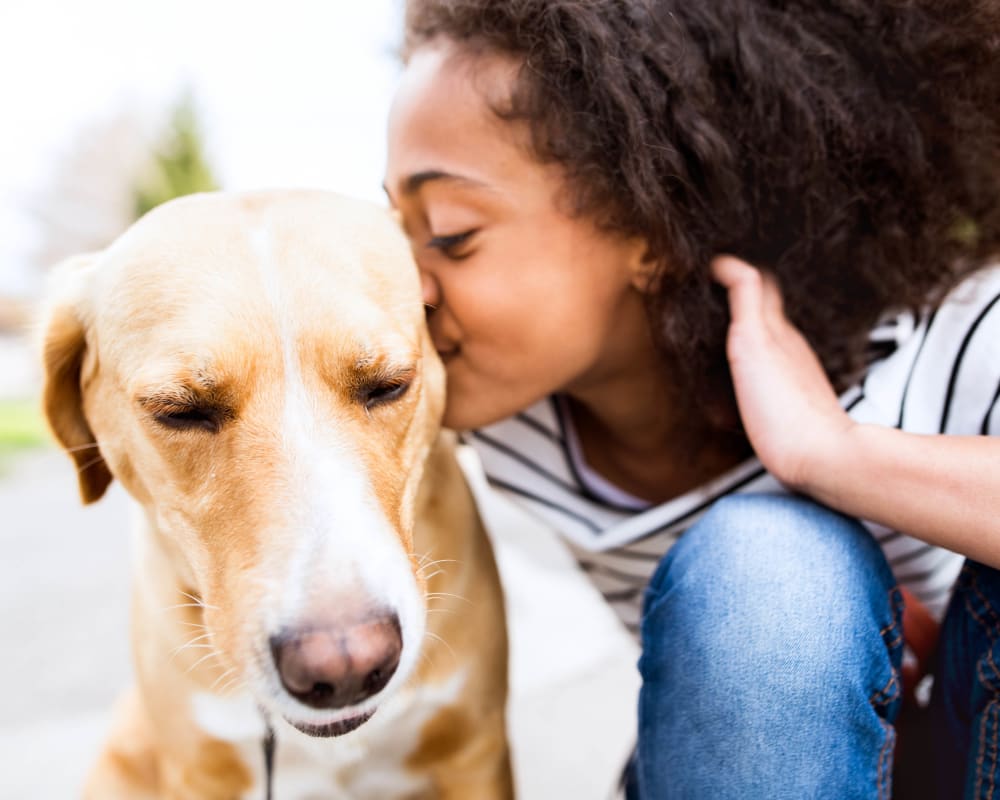 Resident giving her dog a kiss outside at Redstone at SanTan Village in Gilbert, Arizona