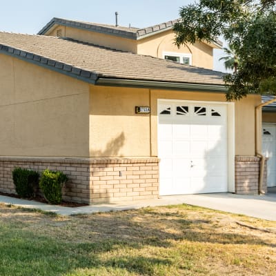 A home with a garage and driveway at Carl Vinson Park in Lemoore, California