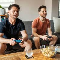 Resident playing video games in living room  at Glenreed Apartments in Glenarden, Maryland