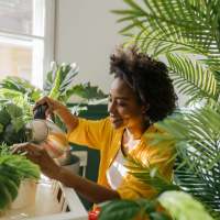 Resident watering her plant in her apartment at Mount Hope Lofts in Rochester, New York