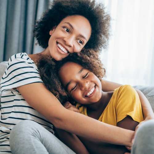 A mother hugging her daughter in the living room at Stone Village Apartments in Reno, Nevada