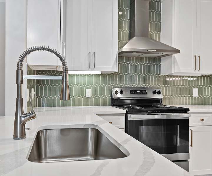 Apartment kitchen with sink and stove at Seagrove in Conroe, Texas