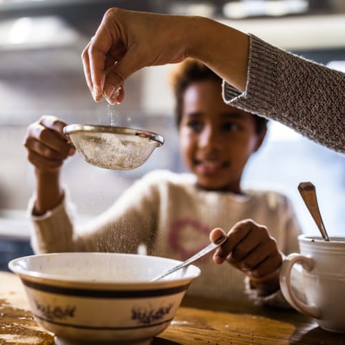 A child and parent baking in a kitchen at Vesta Bouldercrest in Atlanta, Georgia