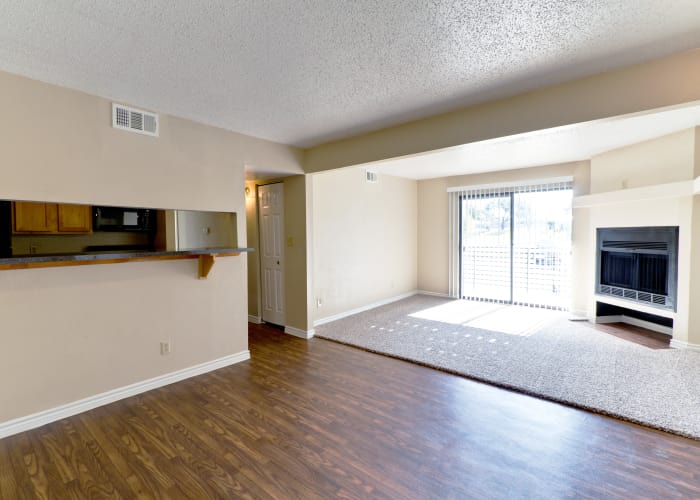 Hardwood floors, plush carpet, and a fireplace in model home's living area at The Belmont in Grand Prairie, Texas