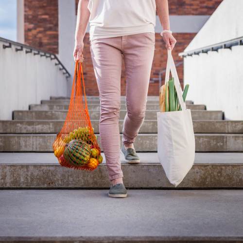 A resident carrying groceries home near Olivera Senior Apartments in Pomona, California