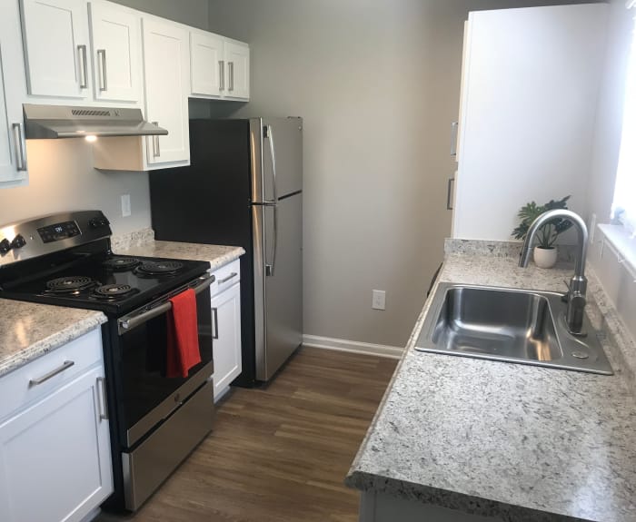 Kitchen with hardwood floors and granite-style countertops in apartment home at Keystone Farms in Nashville, Tennessee