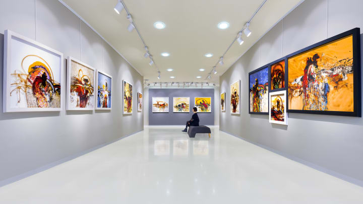 A woman sitting in a Tampa art museum looking at exhibits on the wall.