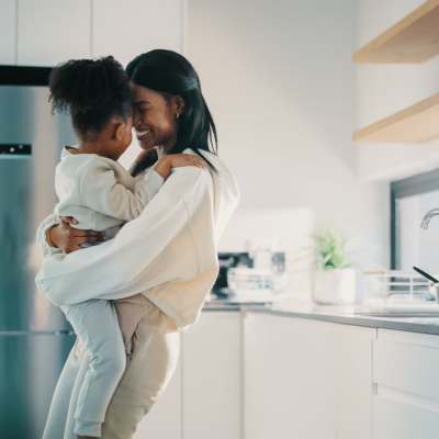 Woman hugging her child in a spacious kitchen with stainless steel equipment at Verde Vue, Savannah, Georgia