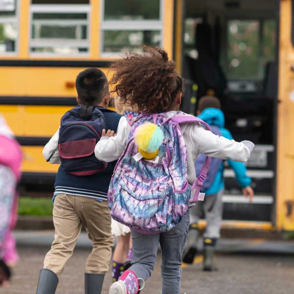 Children joyfully boarding their school bus near Pecan Bend in Mansfield, Texas