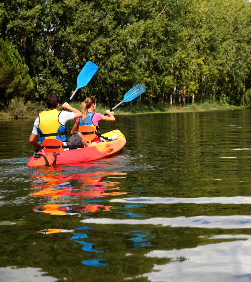 Two people sharing a kayak and rowing it near Sacramento, California, apartments at Waters Edge