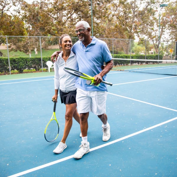 Residents playing tennis at Tampa Gardens Senior Living in Tampa, Florida