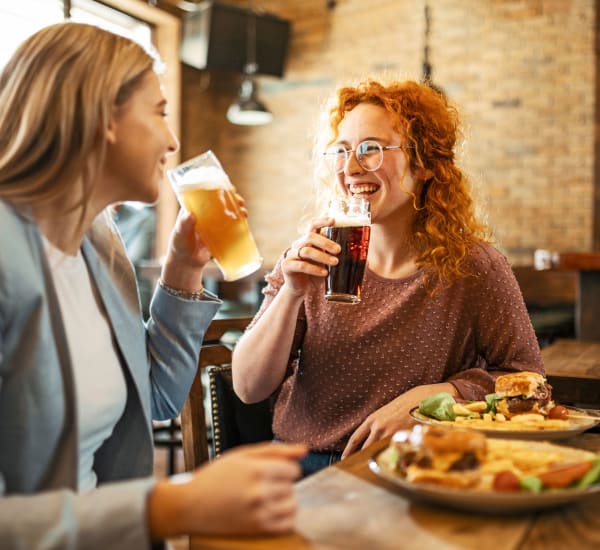 Two smiling women having drinks together near Liberty Mill in Germantown, Maryland