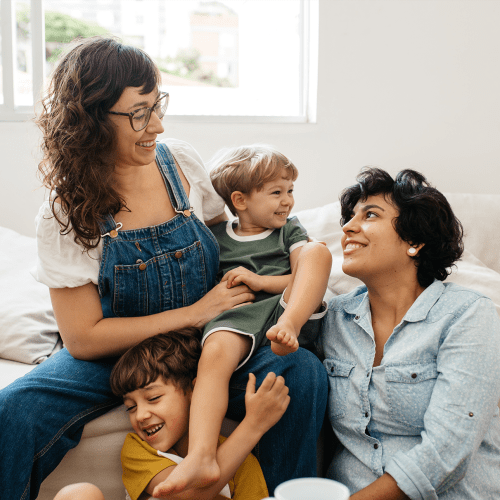 Residents and children sitting on a couch in a home at SOQ in Ridgecrest, California