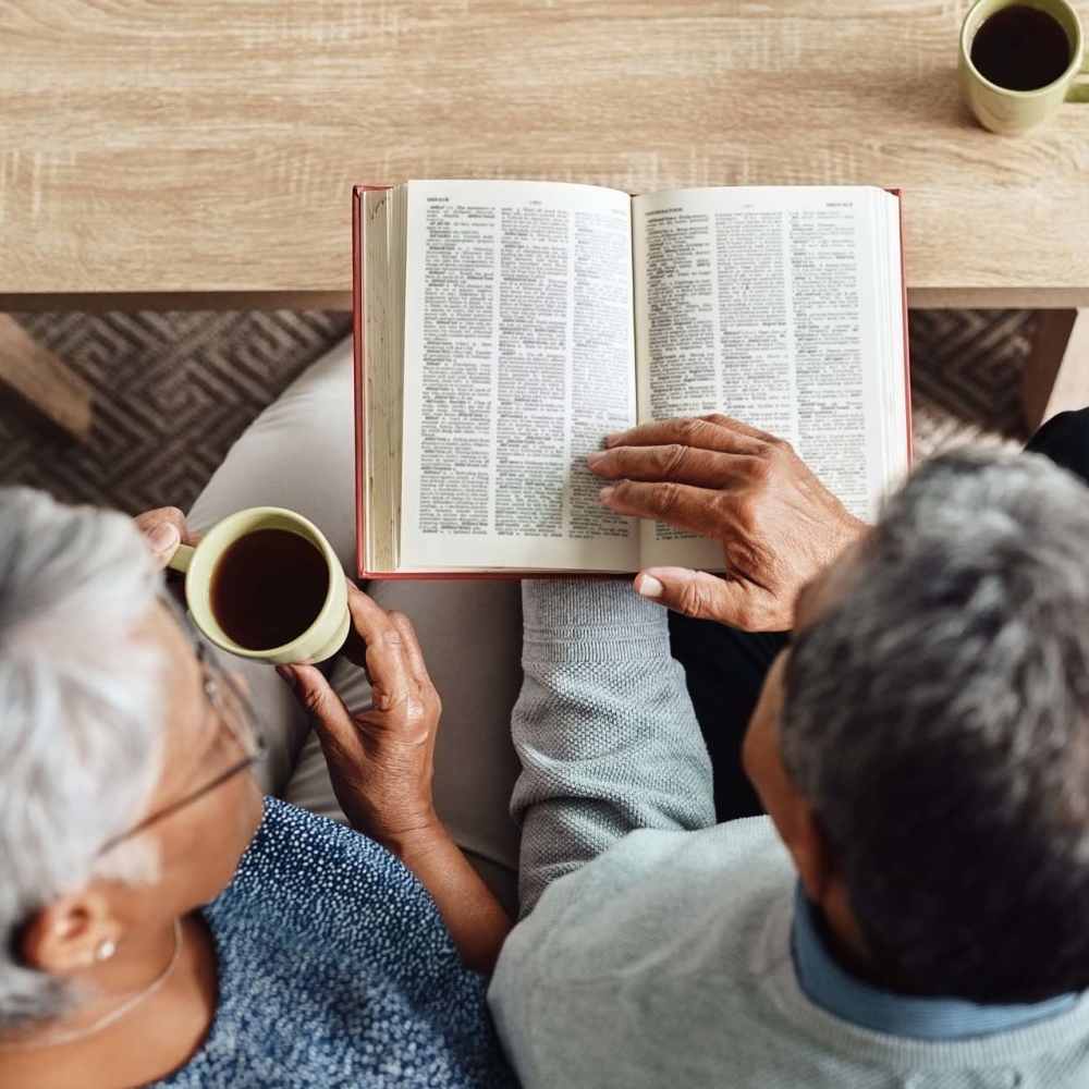 Couple spending good time reading book at Mill Pond Apartments (Buchanan) in Buchanan, Michigan
