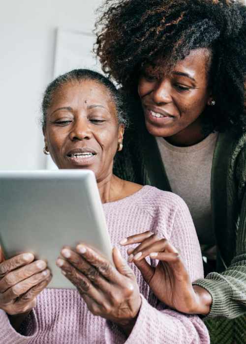 Resident and his daughter using a laptop at Grand Villa of Ocala in Ocala, Florida
