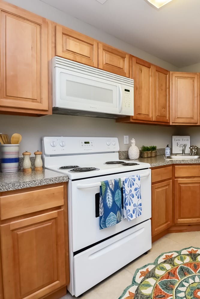 Model kitchen with maple cabinets and white appliances at Lumberton Apartment Homes in Lumberton, New Jersey