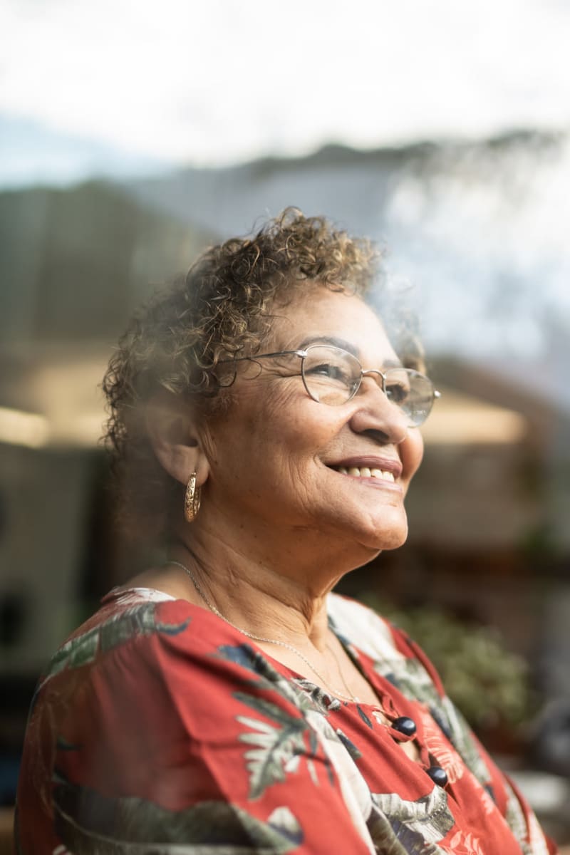 Resident smiling and enjoying the view looking out the window at Trustwell Living of Overland Park in Overland Park, Kansas