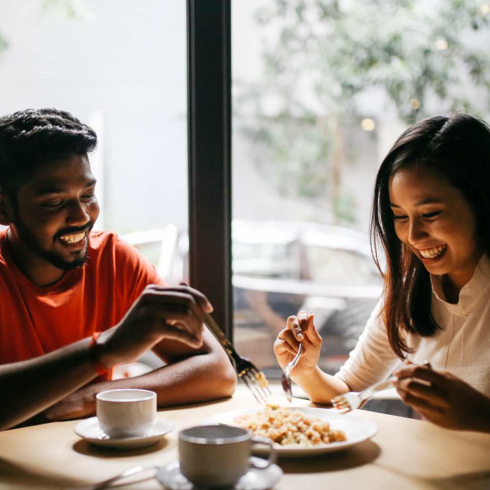 Resident couple sharing a laugh over a meal at their favorite restaurant near Grandview Garden Apartments in Florissant, Missouri