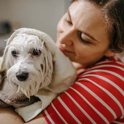 A woman holding her dog wrapped in a towel at Village at Tradition in Port Saint Lucie, Florida
