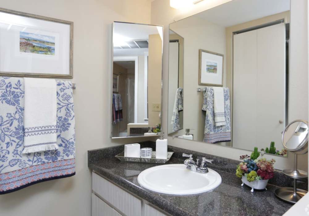 Bright bathroom with large mirror at Wasatch Club Apartments in Midvale, Utah, 